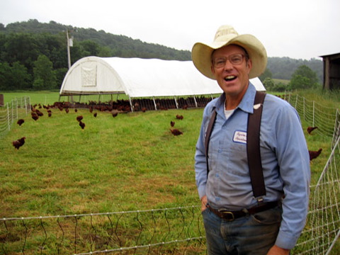 Joel with chickens behind super lite and portable electric fence